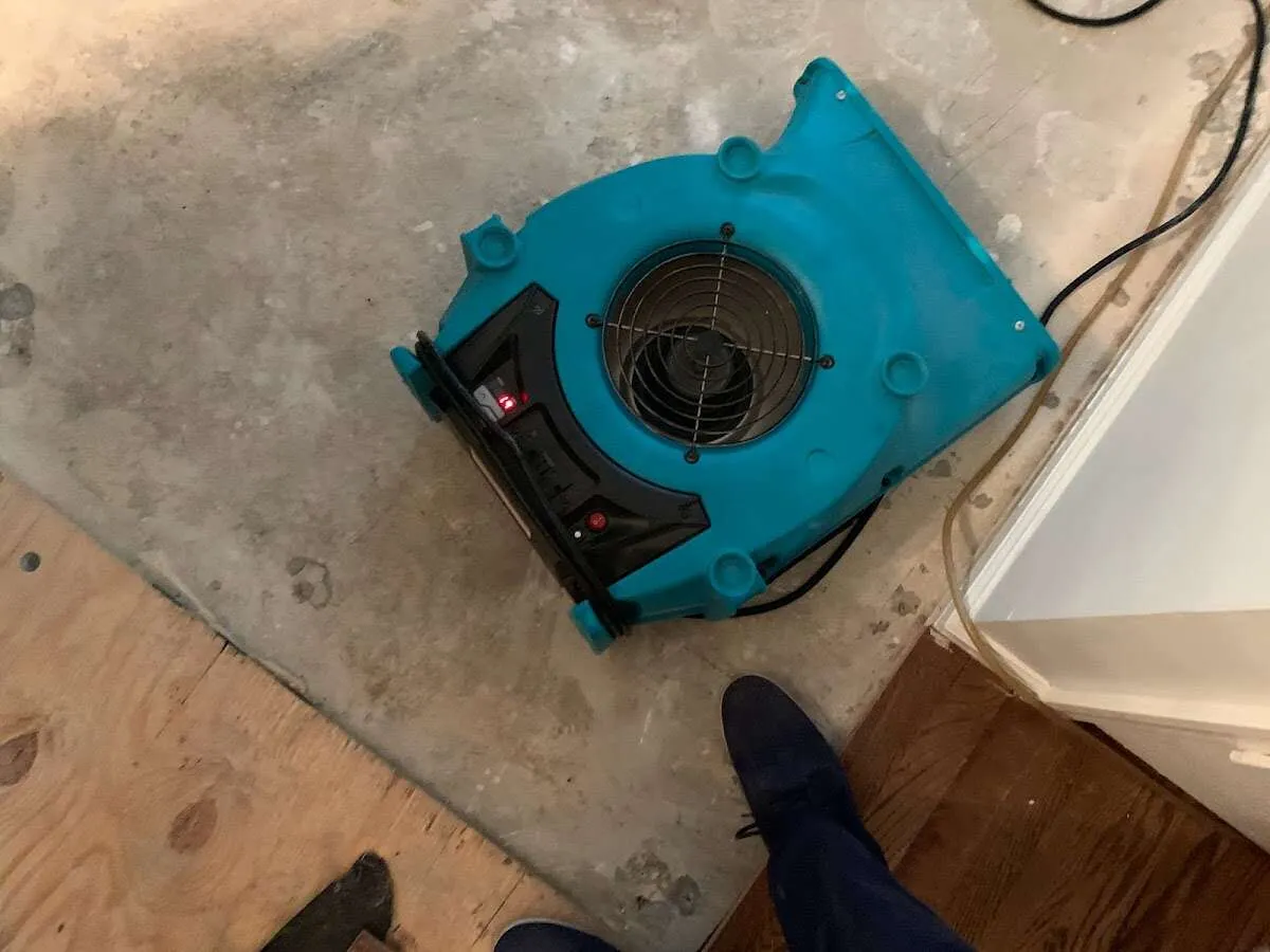 Air mover drying subfloor during Commercial Water Damage Restoration in Texas City
